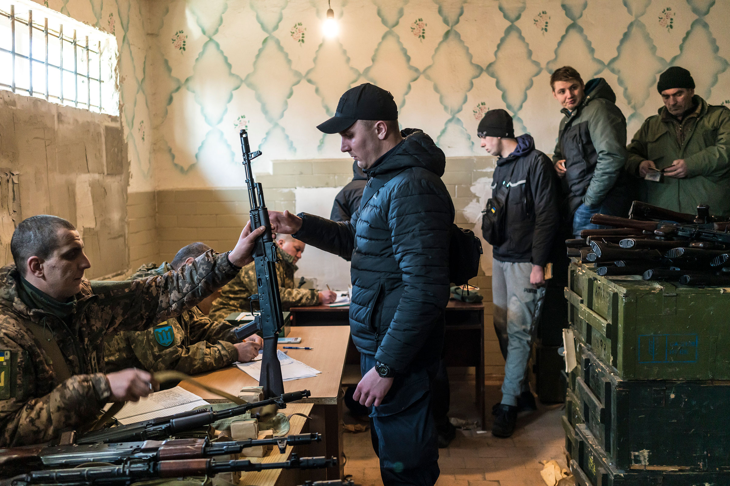 Ukrainian military volunteers receive weapons at a weapons storage facility in Fastiv, on Feb. 25.