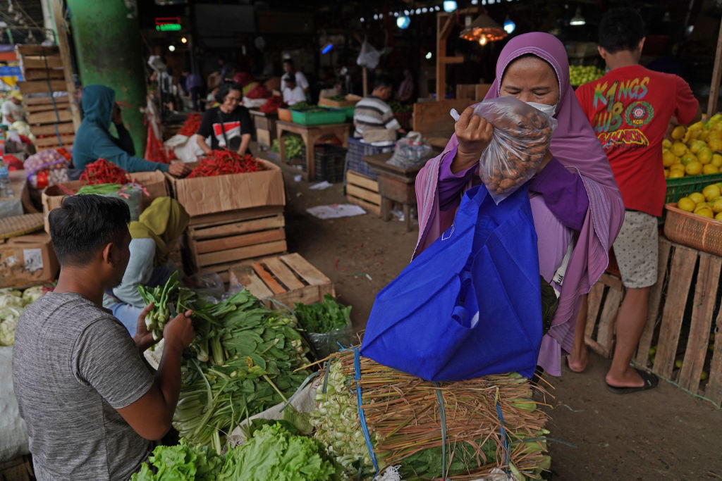 A shopper buys vegetables at Pasar Induk Kramat Jati wholesale market in Jakarta, Indonesia on Feb. 26, 2022. (Dimas Ardian/Bloomberg via Getty Images)