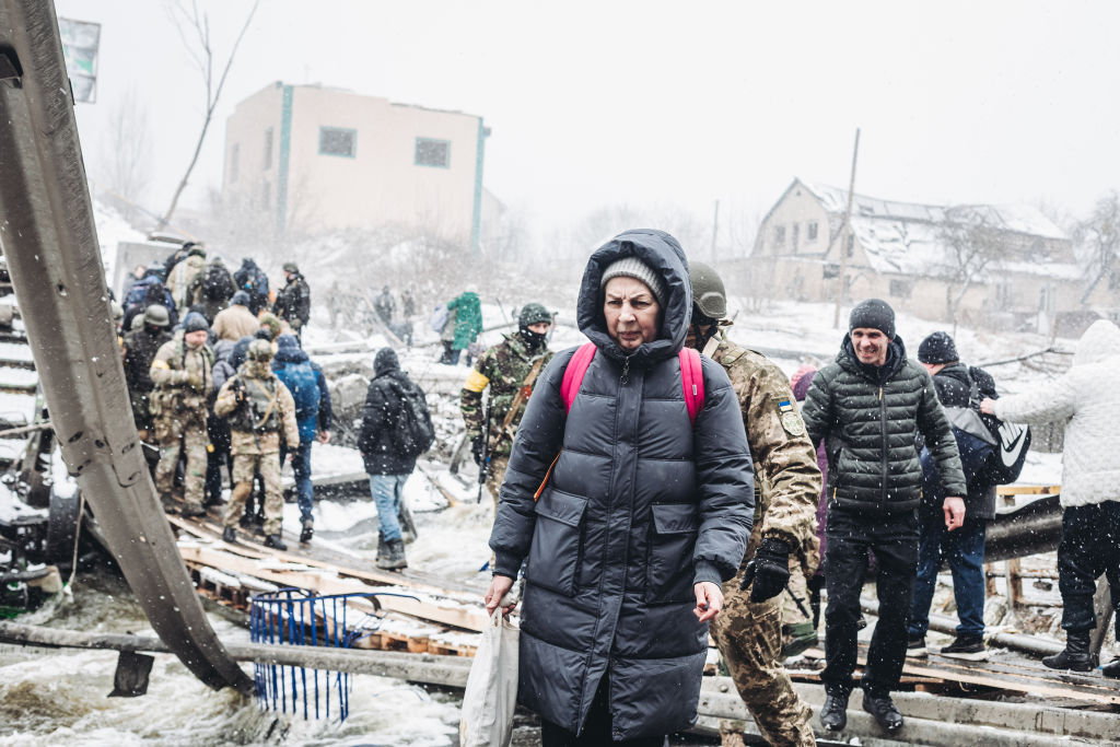 A woman crosses the destroyed bridgeas civilians continue to flee from Irpin due to ongoing Russian attacks in Irpin, Ukraine on March 08, 2022. (Diego Herrera Carcedo-Anadolu Agency)