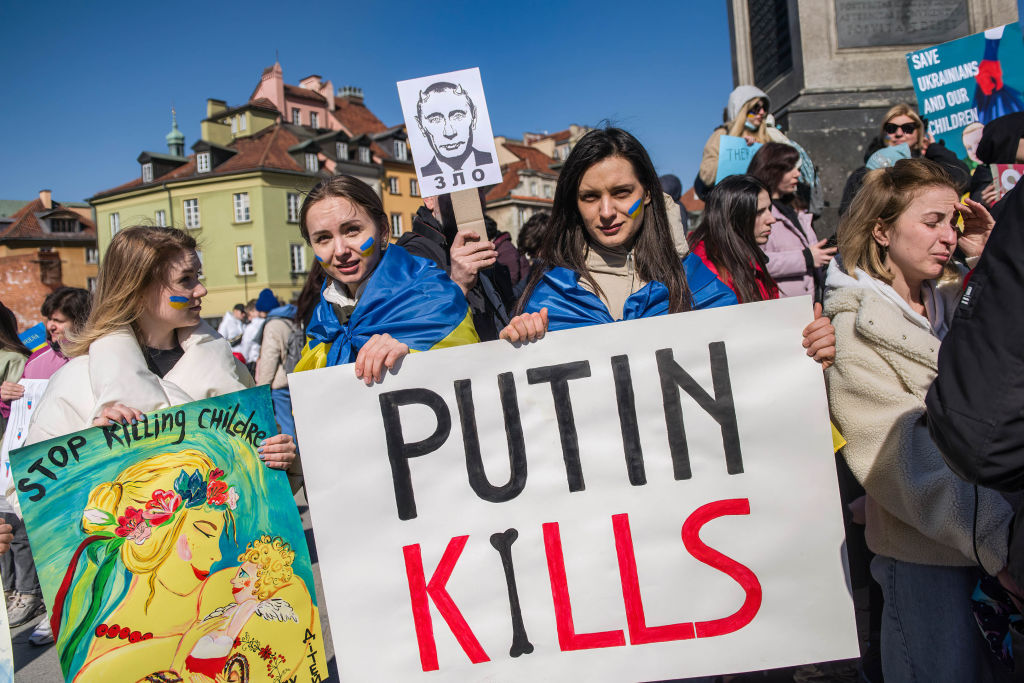 Ukrainian women hold a placard saying "Putin Kills" during a protest. in Warsaw on Mar. 18, 2022 (Attila Husejnow/SOPA Images/LightRocket via Getty Images)