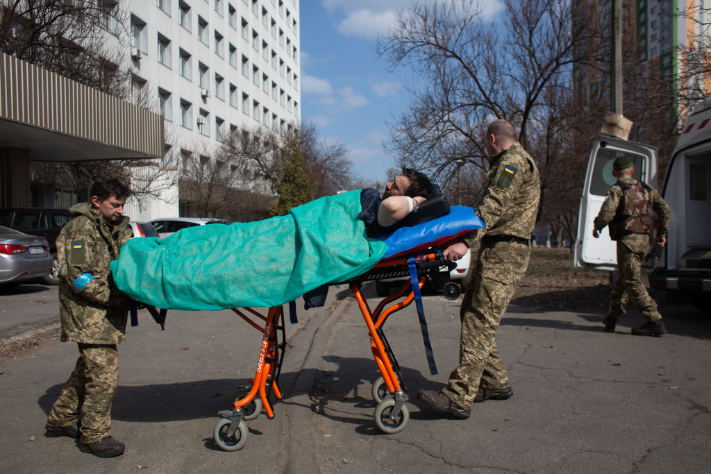 Paramedics transfer a wounded Ukrainian serviceman, Rostyslav, from a hospital on March 24, 2022 in Kyiv, Ukraine. Ukrainian forces have managed to largely halt the Russian advance around the capital, but shelling and air strikes persist, driving up civilian and military casualties caused by Russia's large-scale invasion launched in Feb. 24. (Anastasia Vlasova-Getty Images)