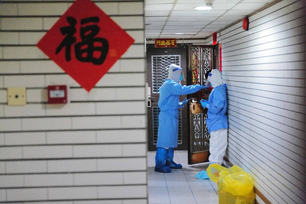 Medical workers carry out door-to-door nucleic acid test at a residential block under restrictions to halt the spread of the Covid-19 coronavirus on Mar. 14, 2022 in Shenzhen, Guangdong, China. (Chen Wen/China News Service via Getty Images)
