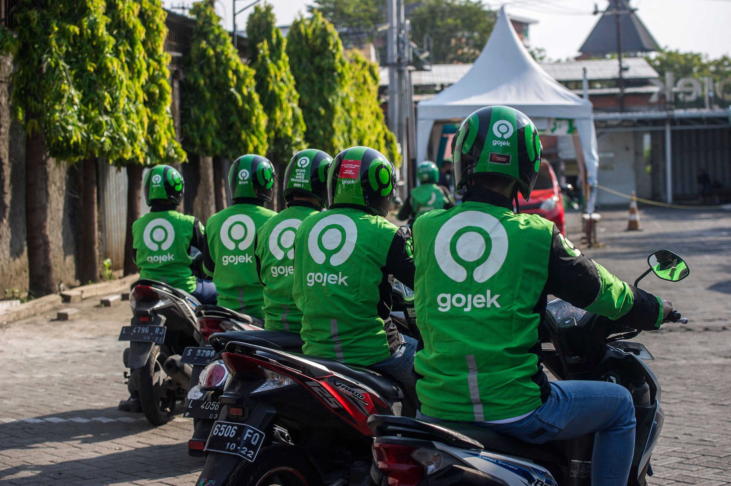 Gojek riders wait for their delivery orders at a distribution centre in Surabaya on May 17, 2021, as Gojek and Tokopedia unveiled a merger to form GoTo Group, creating the largest tech firm in the world's fourth most populous country. (Juni Kriswanto—APF/Getty Images)