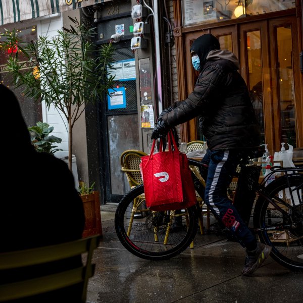 A DoorDash delivery driver riding a bicycle picks up food from Jack's Wife Freda during the first snow of the season on December 09, 2020 in New York City.