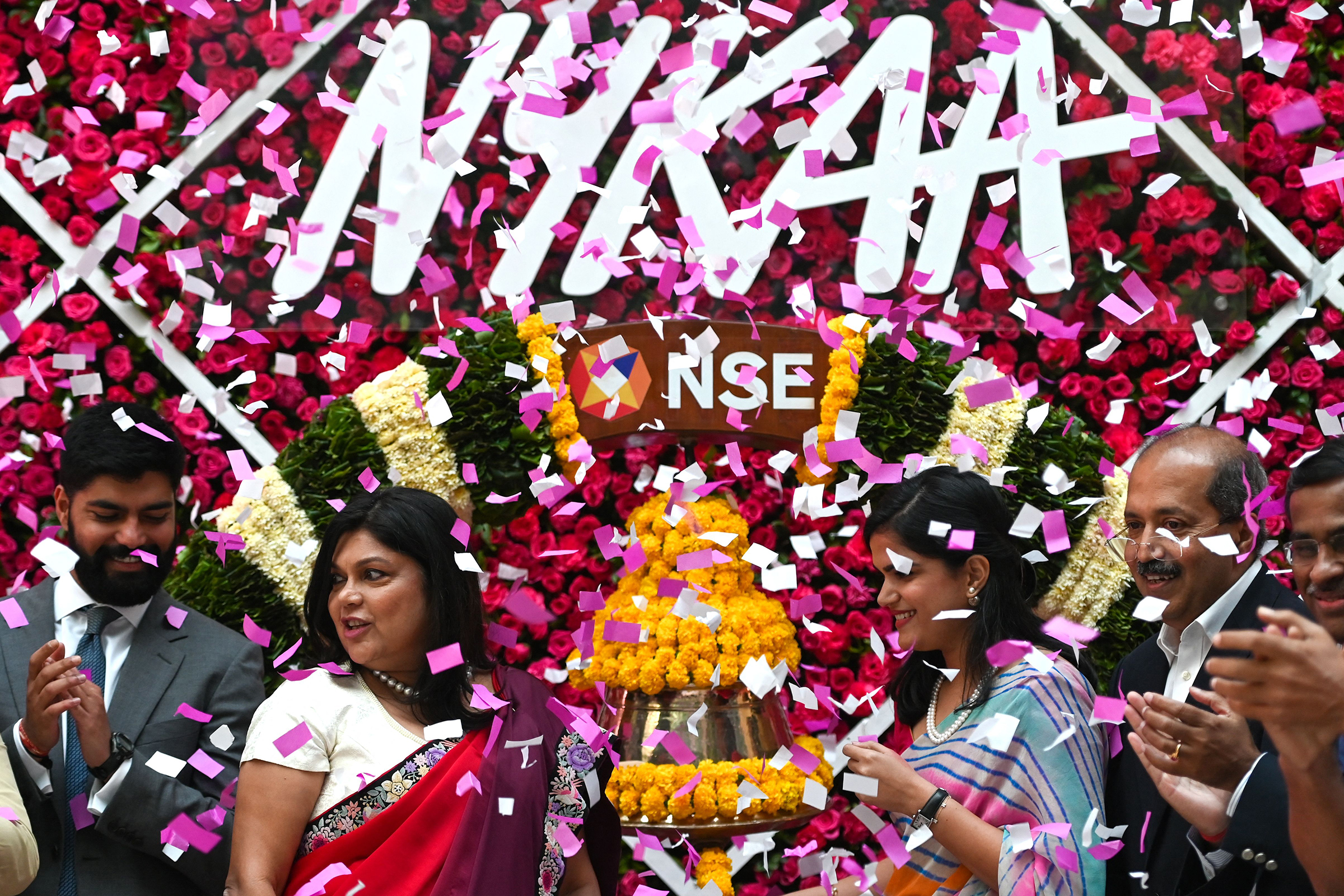 Falguni Nayar (C-L), managing director and CEO of Nykaa, an online marketplace for beauty and wellness products, along with her daughter Advaita (C-R) attends the company's IPO listing ceremony at the National Stock Exchange in Mumbai on November 10, 2021. (Punit Paranjpe—AFP/Getty Images)