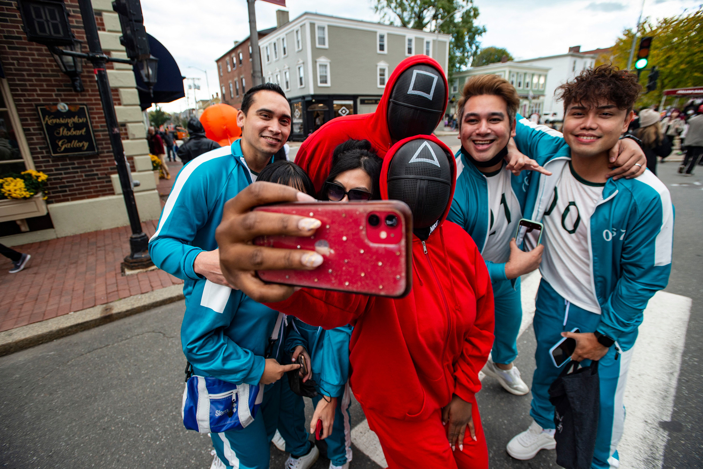 A group dressed as characters from the Netflix show "Squid Game" pose for a 'selfie' on Halloween in Salem, Massachusetts on October 31, 2021. (Joseph Prezioso—AFP/Getty Images)