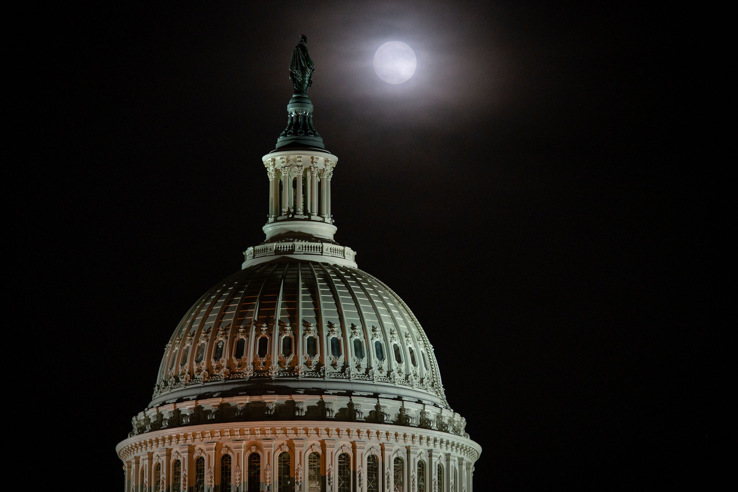 A full moon rises behind the U.S. Capitol Building in Washington, on Nov. 29, 2020. (Graeme Sloan—Sipa USA/AP)