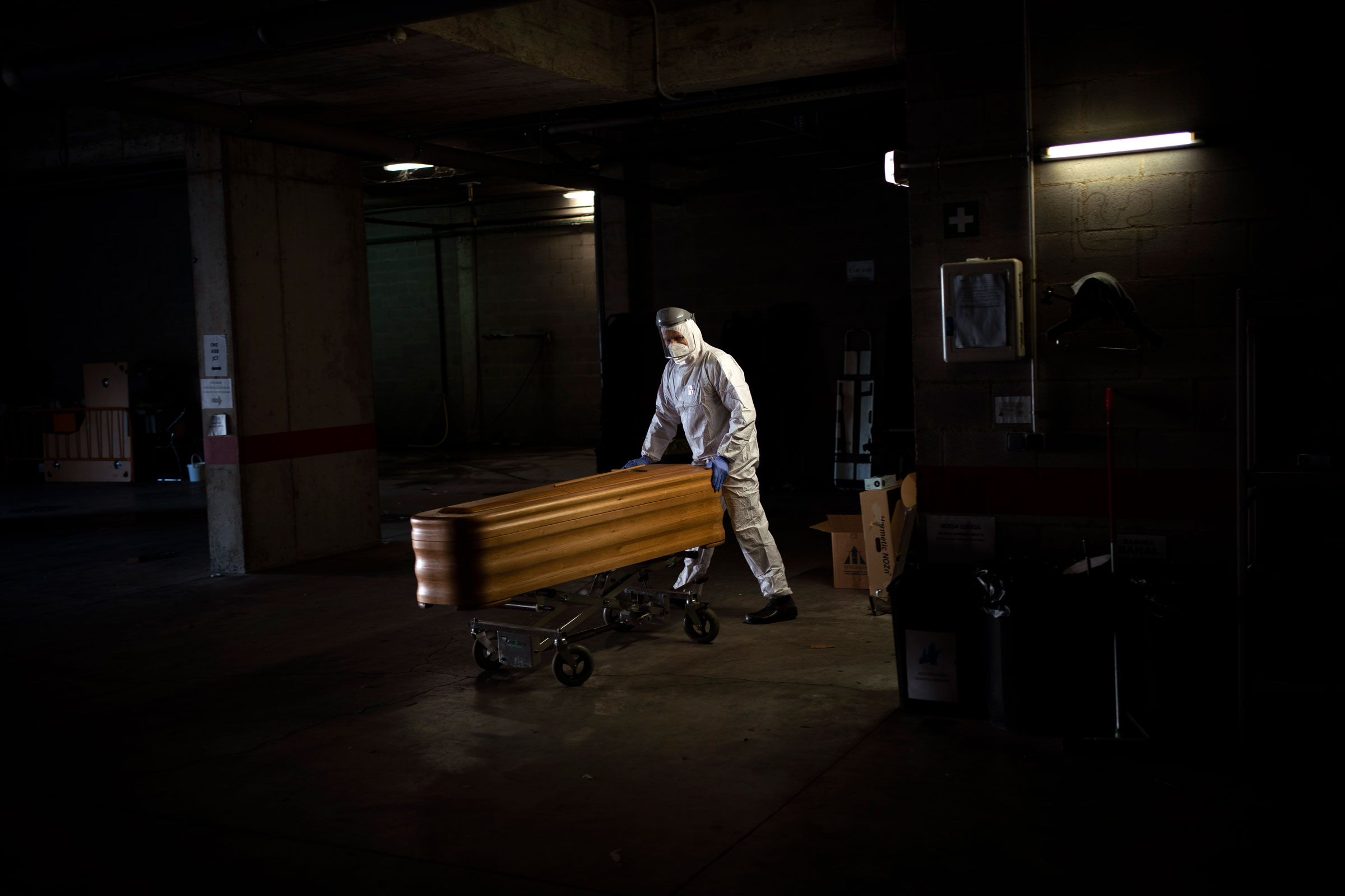 A mortuary worker moves a coffin carrying the body of a person who died of COVID-19 ahead of a funeral at Memora mortuary in Girona, Spain, Thursday, Feb. 4, 2021. (Emilio Morenatti—AP)