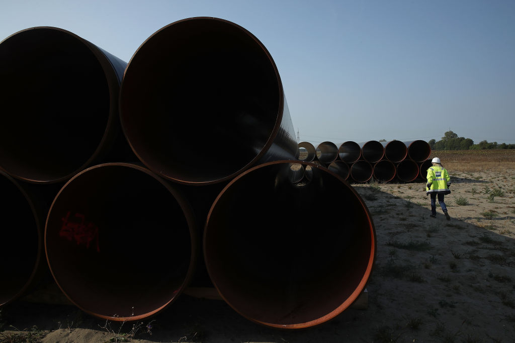A worker walks among sections of stacked steel pipe ahead of construction of the Eugal natural gas pipeline designed to transport Russian natural gas via Nord Stream 2 on August 29, 2018 near Golssen, Germany. (Sean Gallup—Getty Images)