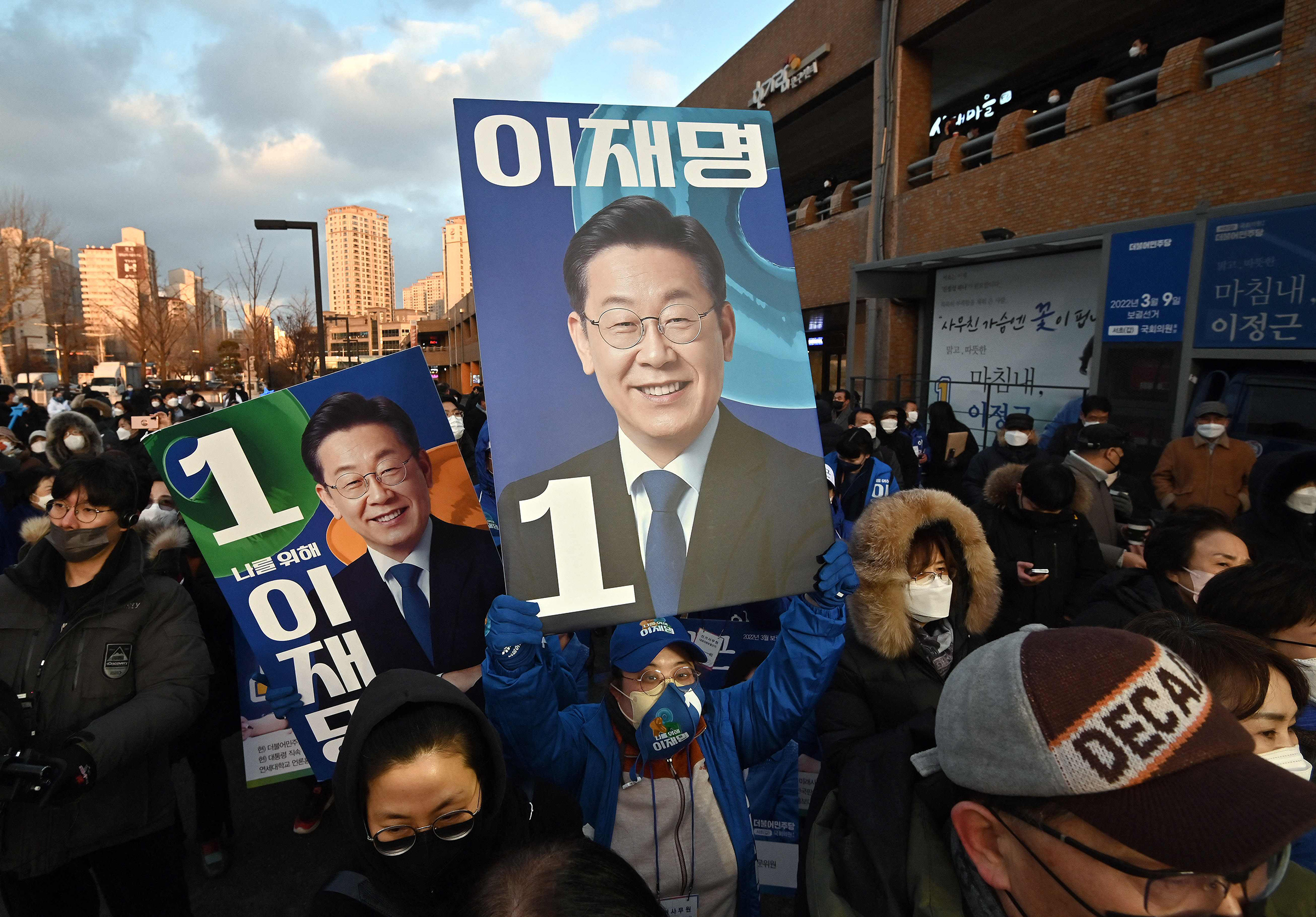 Supporters of Lee Jae-myung hold placards showing pictures of the candidate during an election campaign in Seoul on Feb. 15, as the official presidential campaign period kicked off for a 22-day run ahead of the election on March 9. (Jung Yeon-je—AFP/Getty Images)