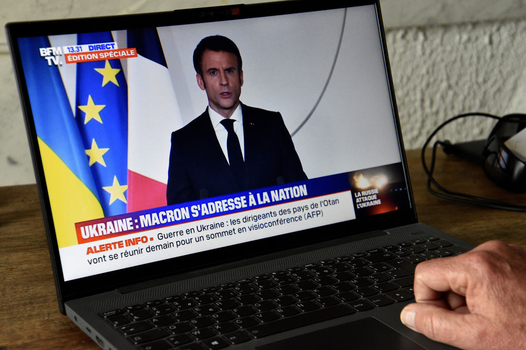A man watches Emmanuel Macron's televised speech against the war in Ukraine on his computer. (Gerard Bottino—SOPA Images/LightRocket/ Getty Images)