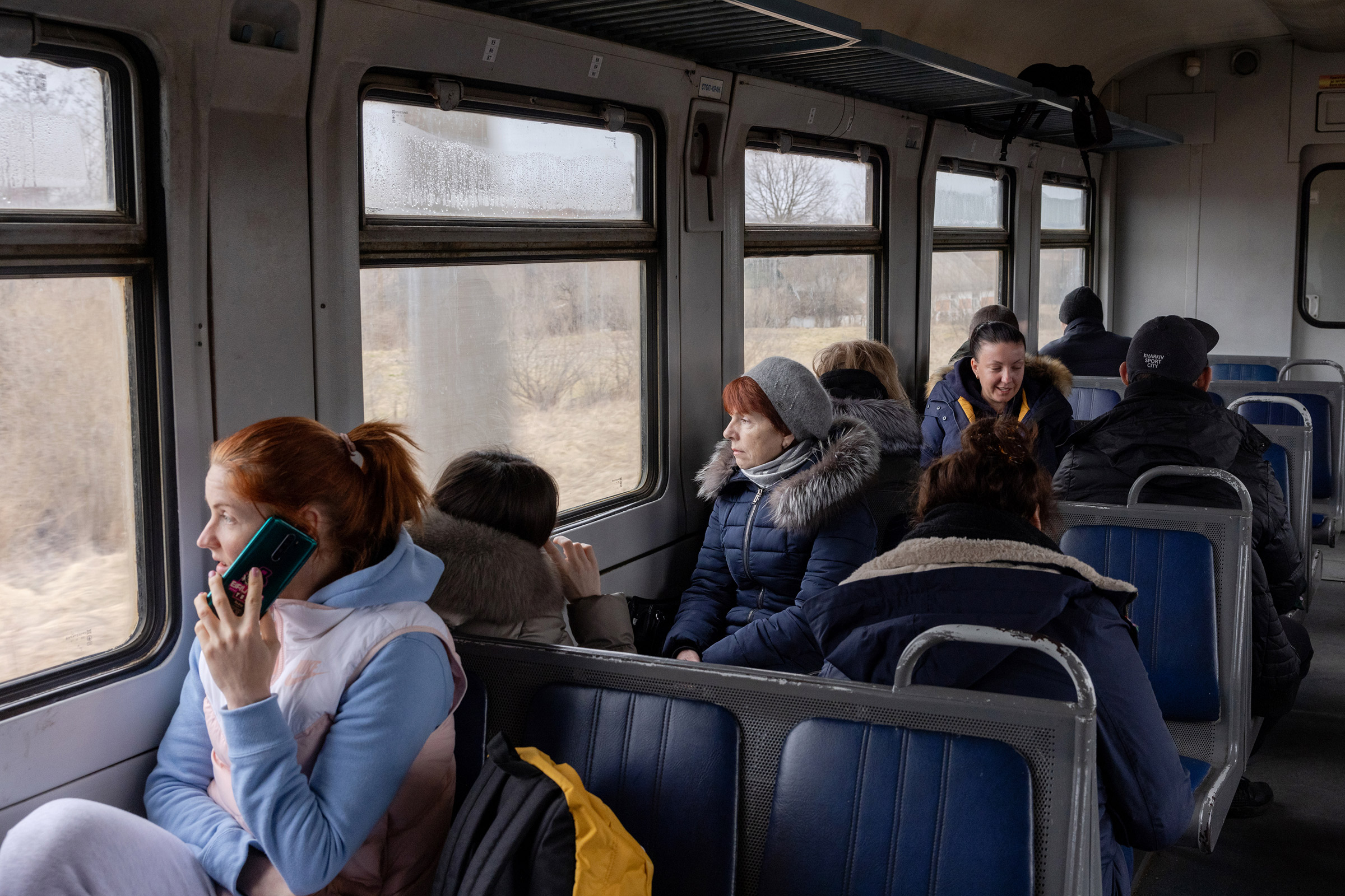 Alisa Kosheleva, (far left) on the phone during the train ride from Poland to Lviv with other mothers on their own journeys towards their children on March 6 (Natalie Keyssar for TIME)
