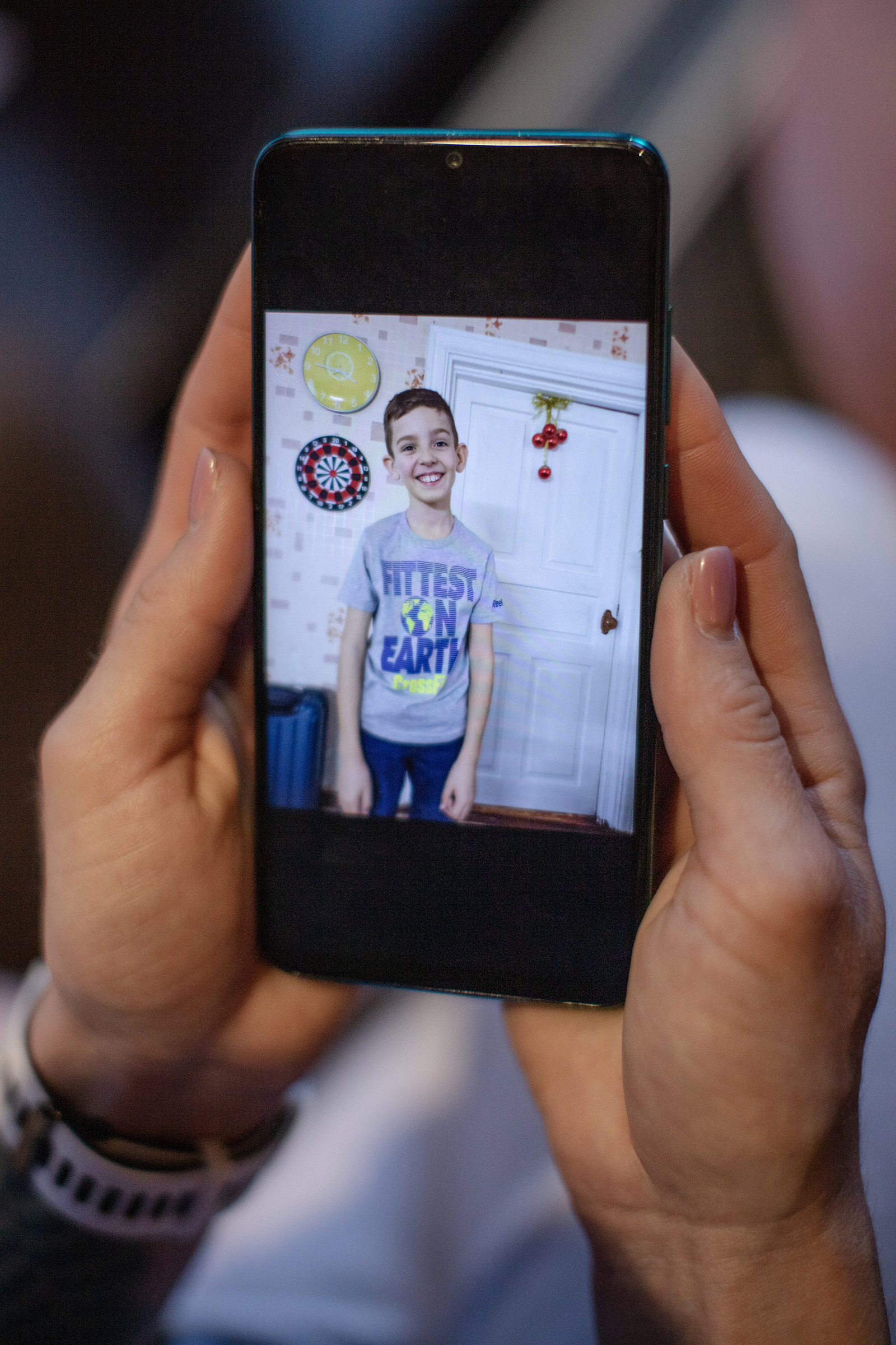 Alisa Kosheleva shows a photo of her son on her cell phone in Lviv on March 8 (Natalie Keyssar for TIME)