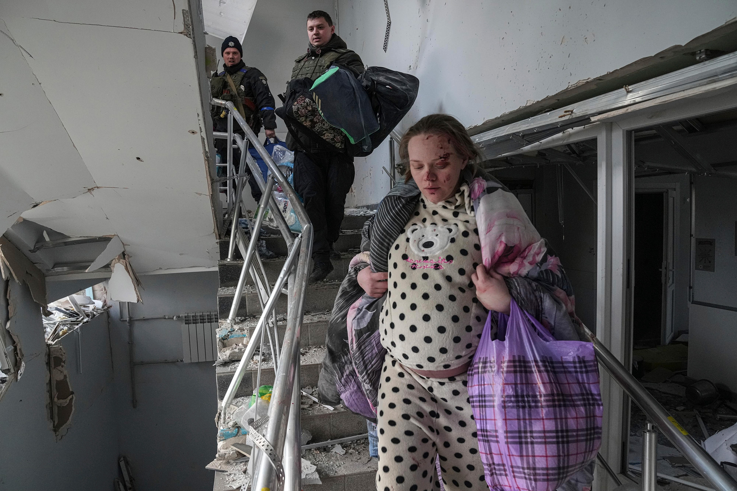An injured pregnant woman walks downstairs in the damaged by shelling maternity hospital in Mariupol, Ukraine, March 9, 2022. Evgeniy Maloletka—AP
