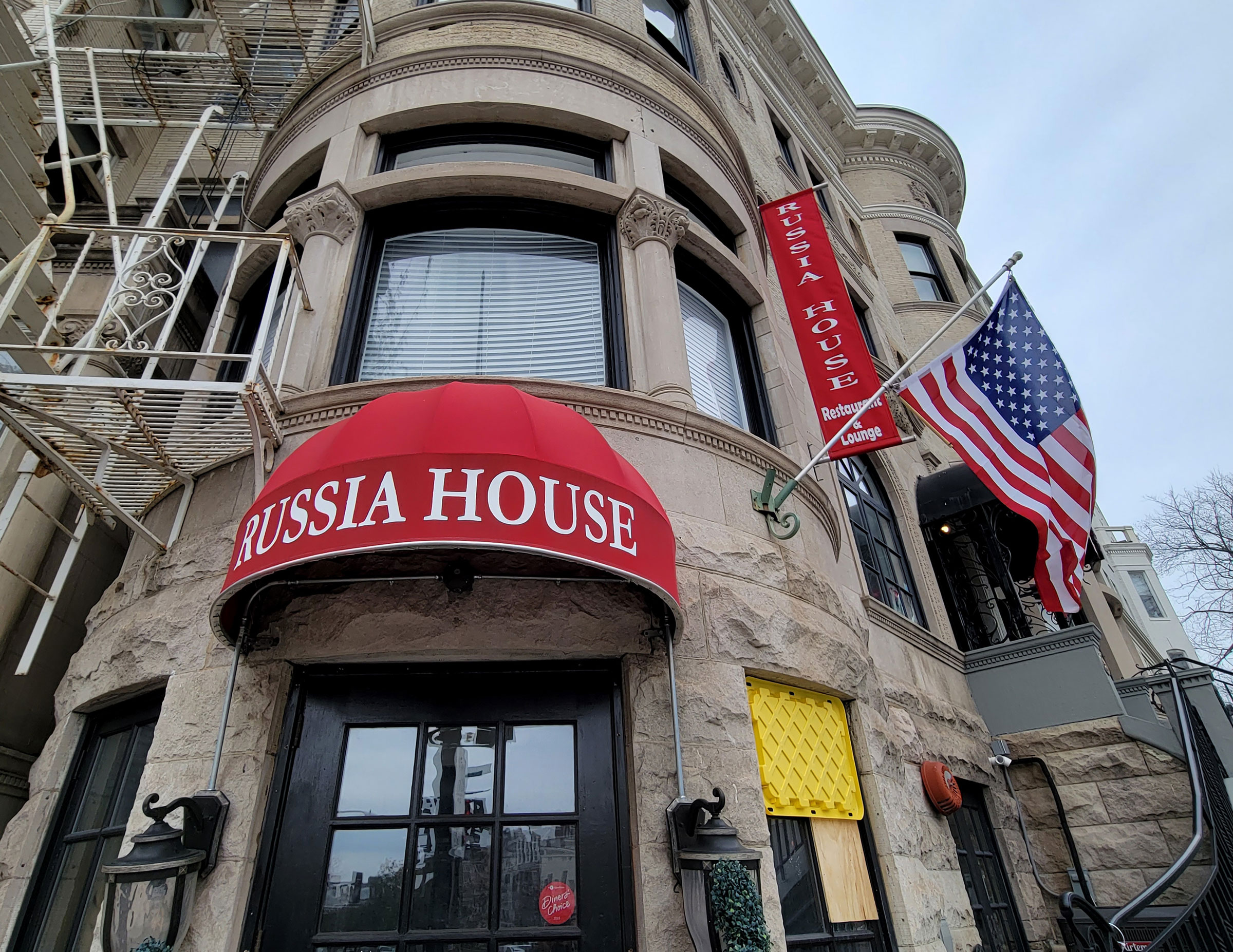 The Russia House bar and restaurant waves the American flag outside its entrance on Connecticut Avenue in Washington, DC on Tuesday, March 1, 2022. Vandals broke a window at lower right after the Russian invasion of Ukraine. (Pat Benic—UPI/Shutterstock)