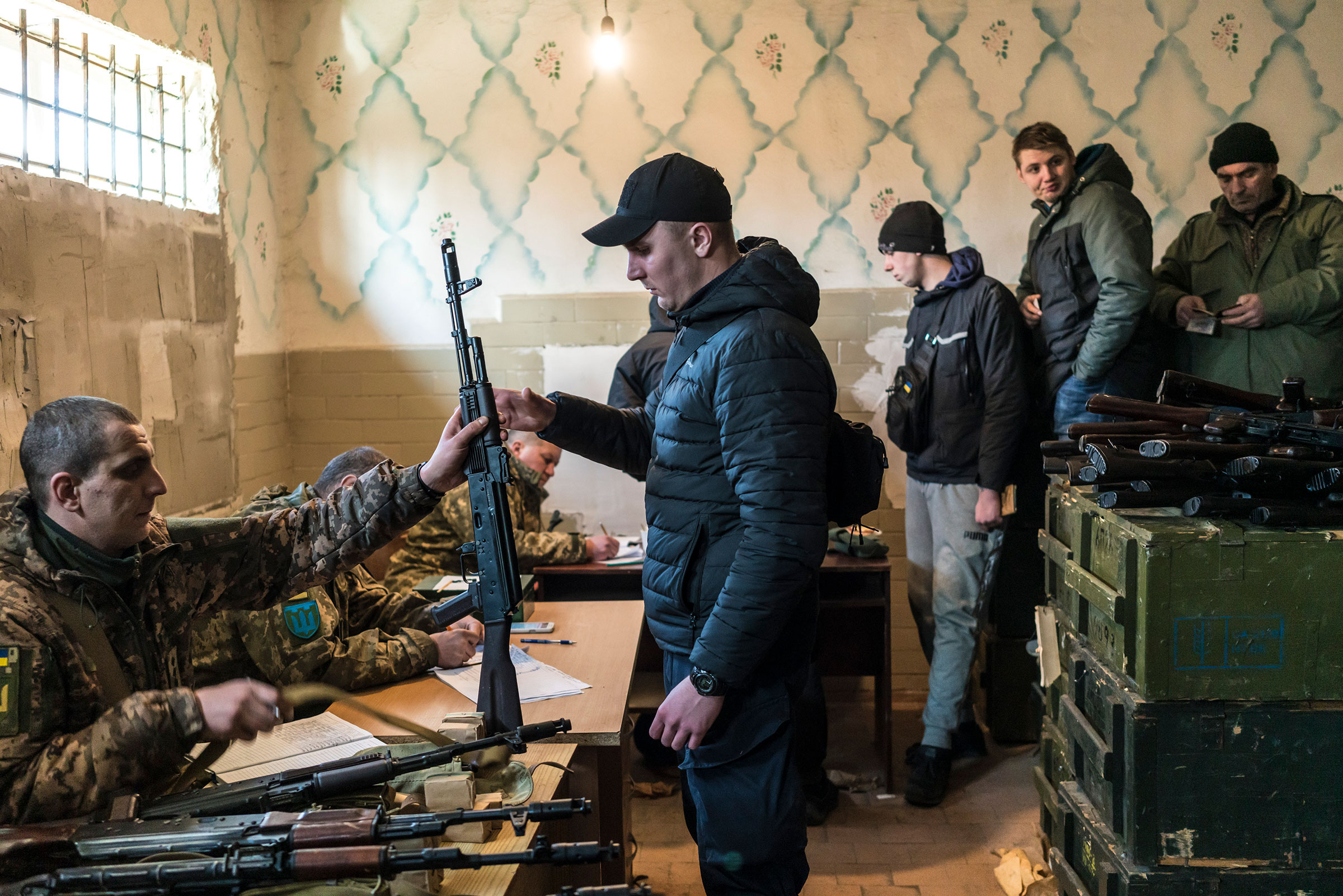 Ukrainian volunteers receive rifles at a weapons storage facility in Fastiv on Feb. 25. (Brendan Hoffman—The New York Times/Redux)
