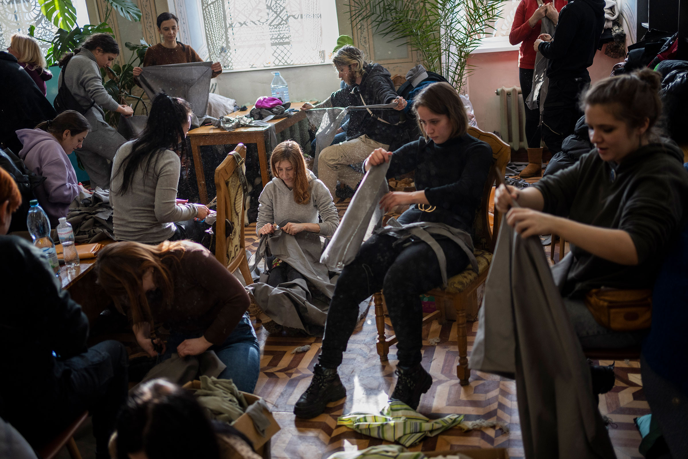 Volunteers tear cloth into strips to make camouflage nets in Lviv on Feb. 28. (Bernat Armangue—AP)