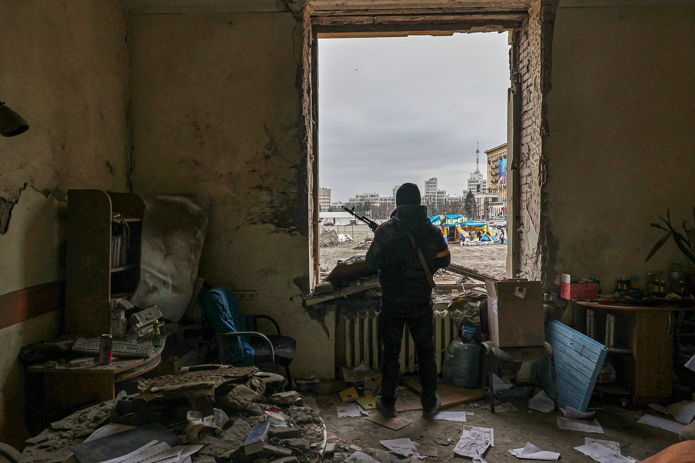 A member of the Territorial Defense Forces stands inside the damaged Kharkiv regional administration building in the aftermath of a shelling in downtown Kharkiv on March 1. (Sergey Kozlov—EPA-EFE/Shutterstock)