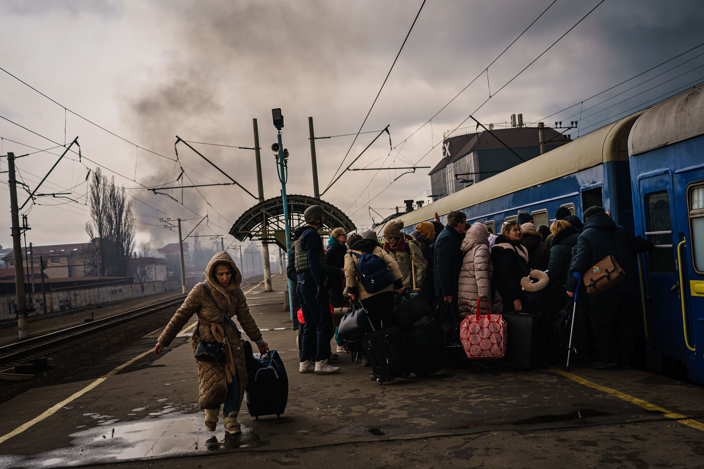 Civilians, mostly women and children rush to board any train car that still has any room on it, as the sounds of battle gunfire and bombing fighting between Russian and Ukrainian forces draw closer to the city of Irpin on March 4. (Marcus Yam—Los Angeles Times/Shutterstock)