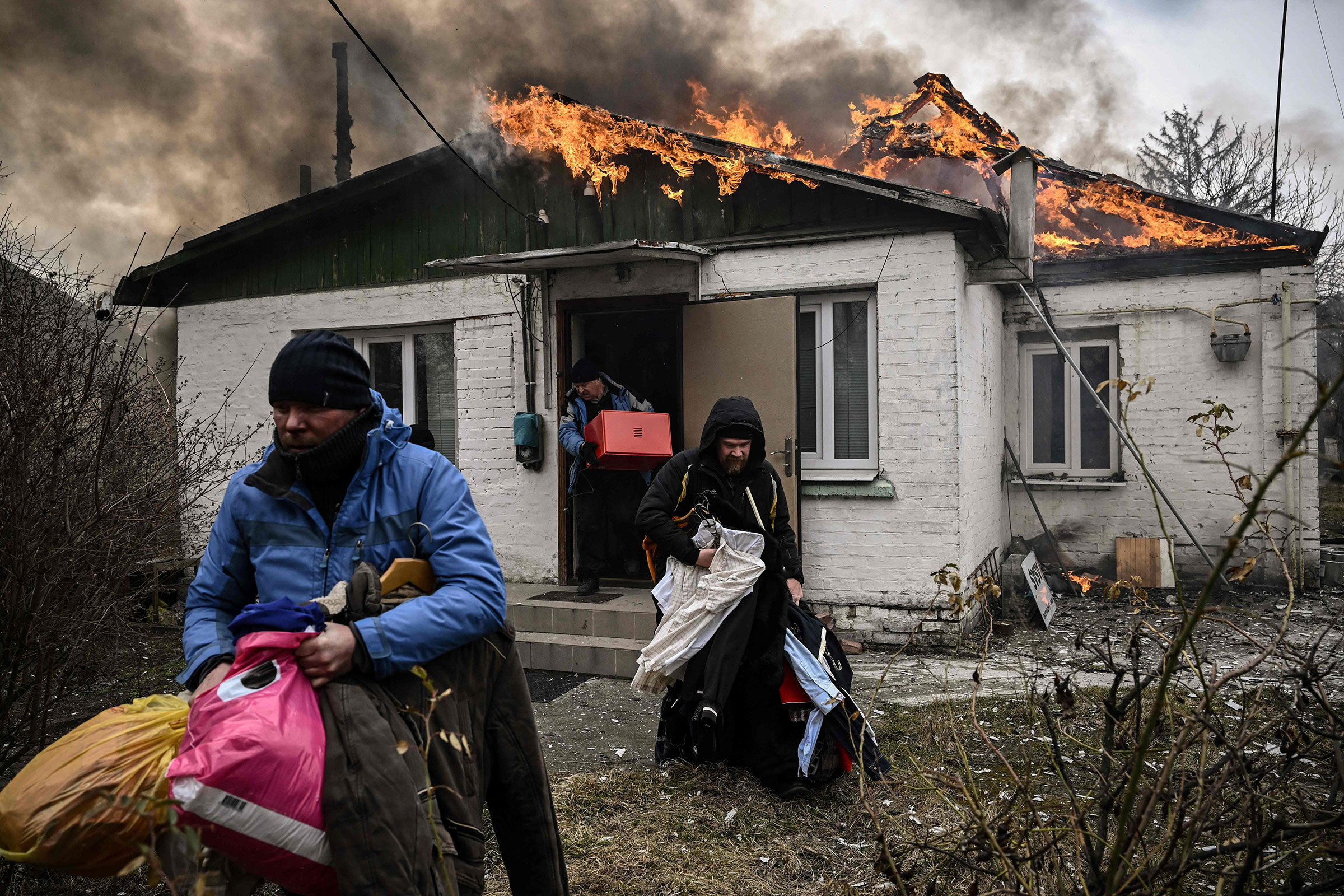 People remove personal belongings from a burning house after being shelled in the city of Irpin on March 4.