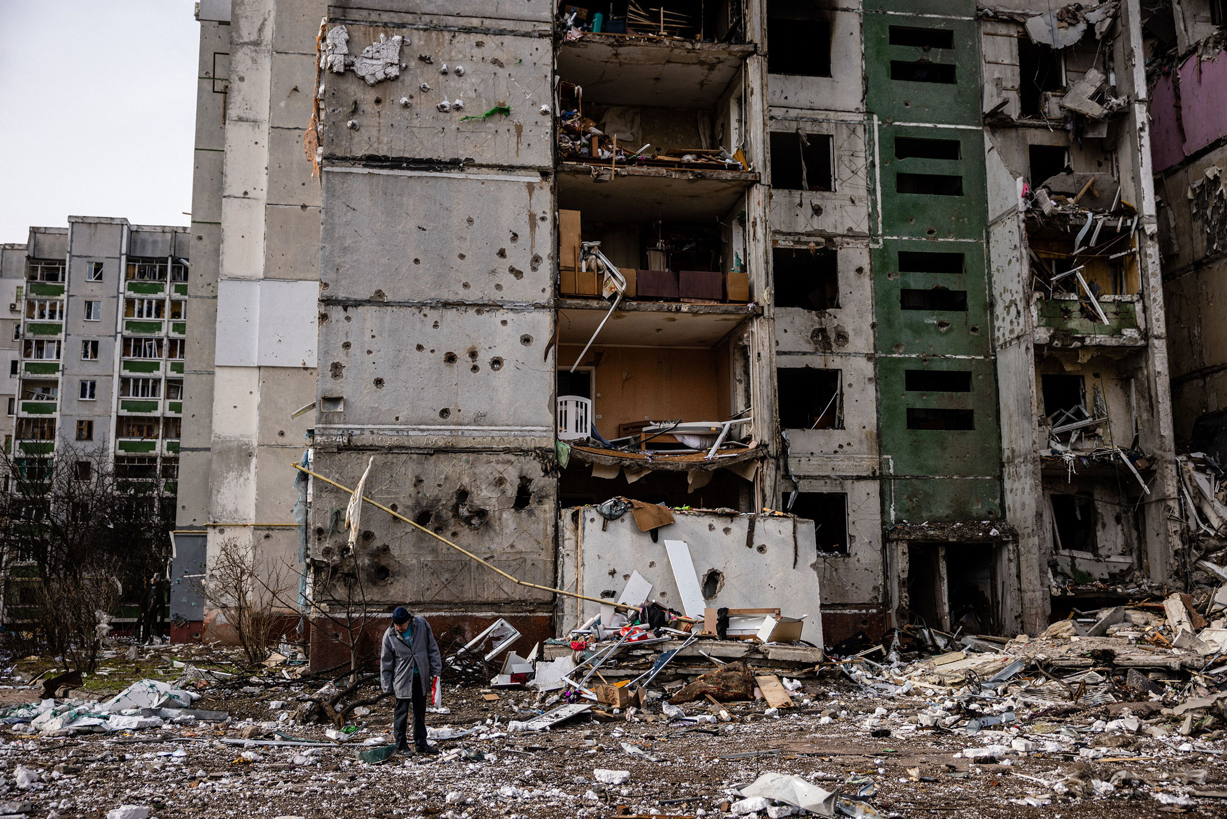 A man stands in front of a residential building damaged in a shelling in the city of Chernihiv on March 4.