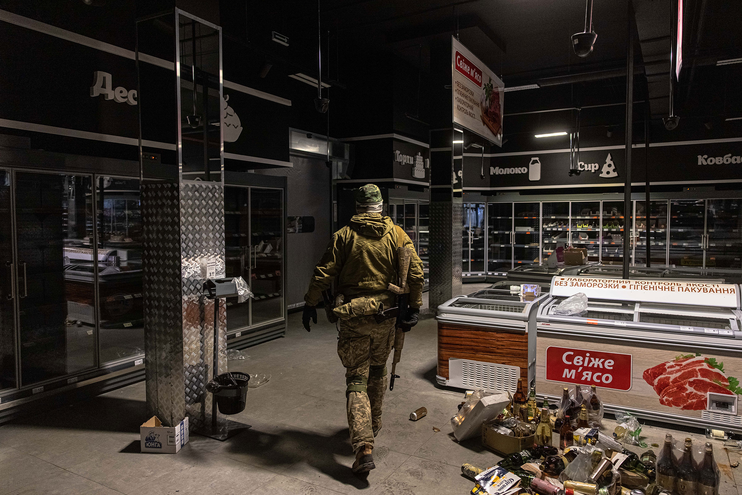 A Ukrainian military member walks to collect water and other goods from an abandoned supermarket to distribute to local residents, in Irpin city, Kyiv on March 3.