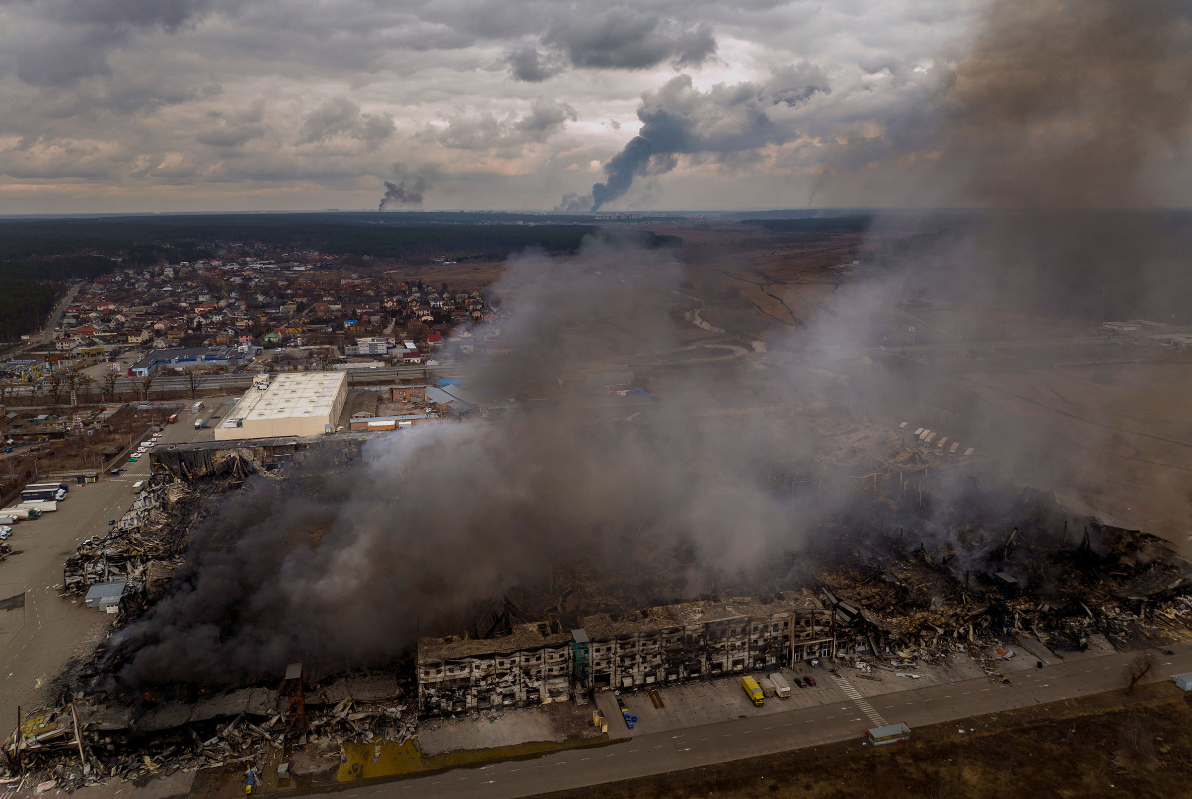 A factory and a store burning after being bombarded in Irpin, in the outskirts of Kyiv, on March 6. (Emilio Morenatti—AP)