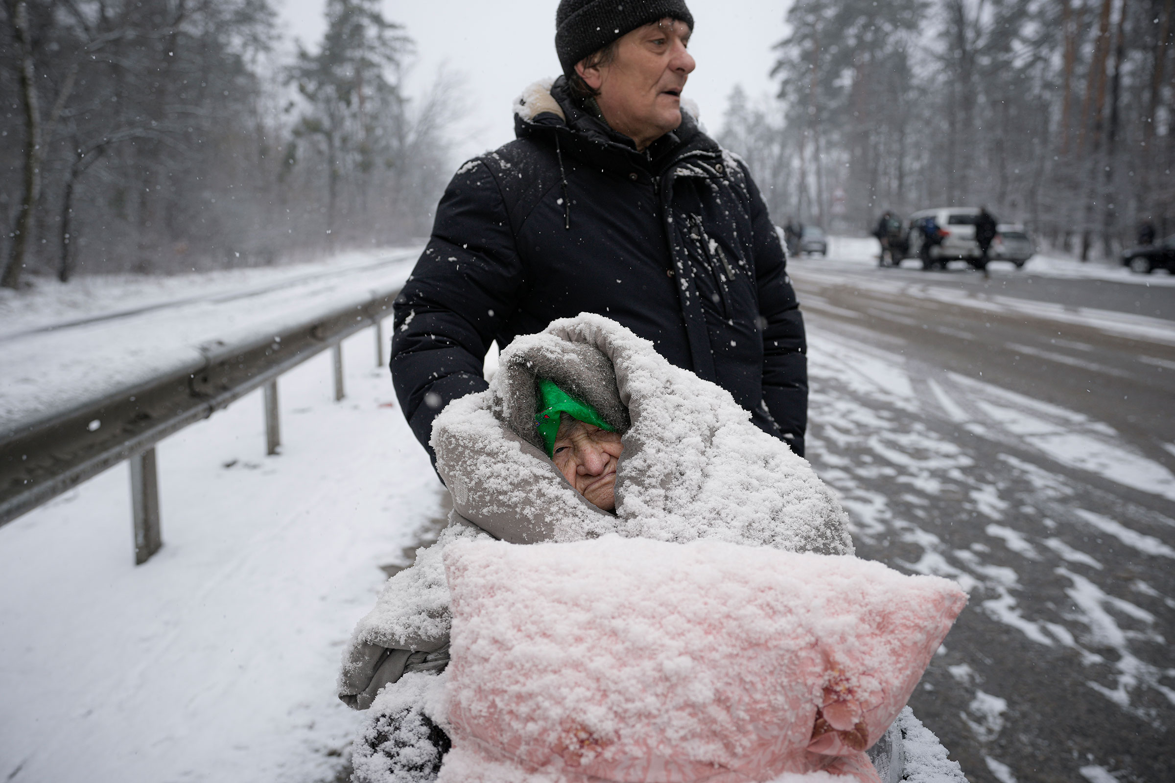 An elderly woman is coated in snow as she sits in a wheelchair after being evacuated from Irpin, on the outskirts of Kyiv on March 8.