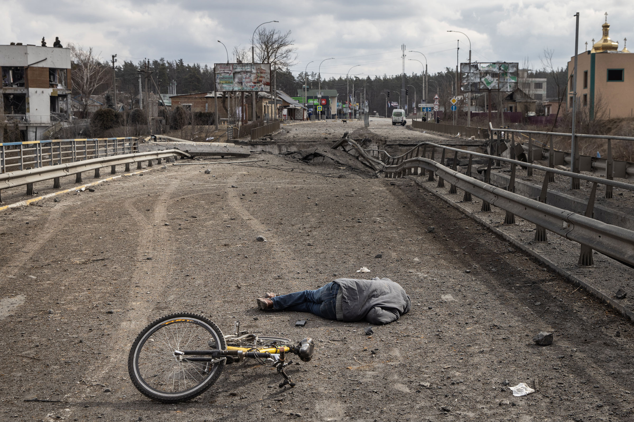 The body of a civilian, whose cause of death was not confirmed, is seen on a destroyed bridge used to evacuate residents from Irpin after Russian forces entered the city on March 7. Four civilians were killed on March 6 by mortar fire along the road leading from Irpin to Kyiv, which has been a key evacuation route for people fleeing Russian forces advancing from the north.