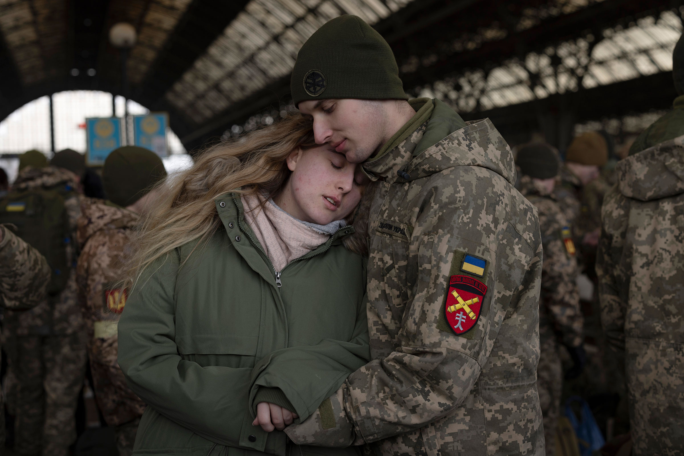Eugene says goodbye to his partner Tanya before boarding a train to Dnipro from the main train terminal in Lviv on March 9. (Dan Kitwood—Getty Images)