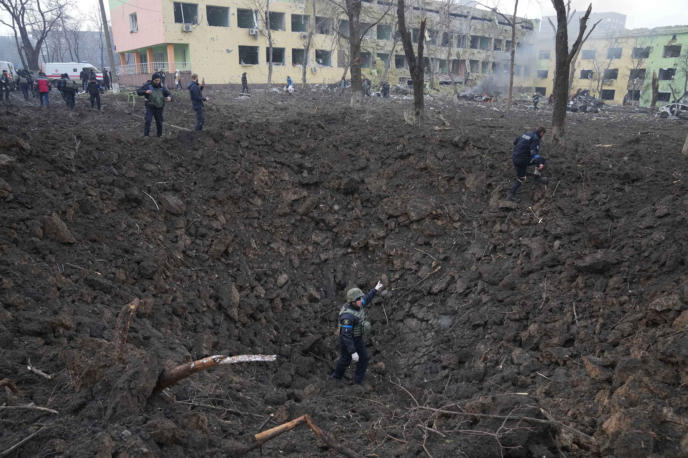 Ukrainian soldiers and emergency employees work at the site of the damaged maternity hospital in Mariupol on March 9. A Russian attack severely damaged the maternity hospital in the besieged port city of Mariupol. (Evgeniy Maloletka—AP)