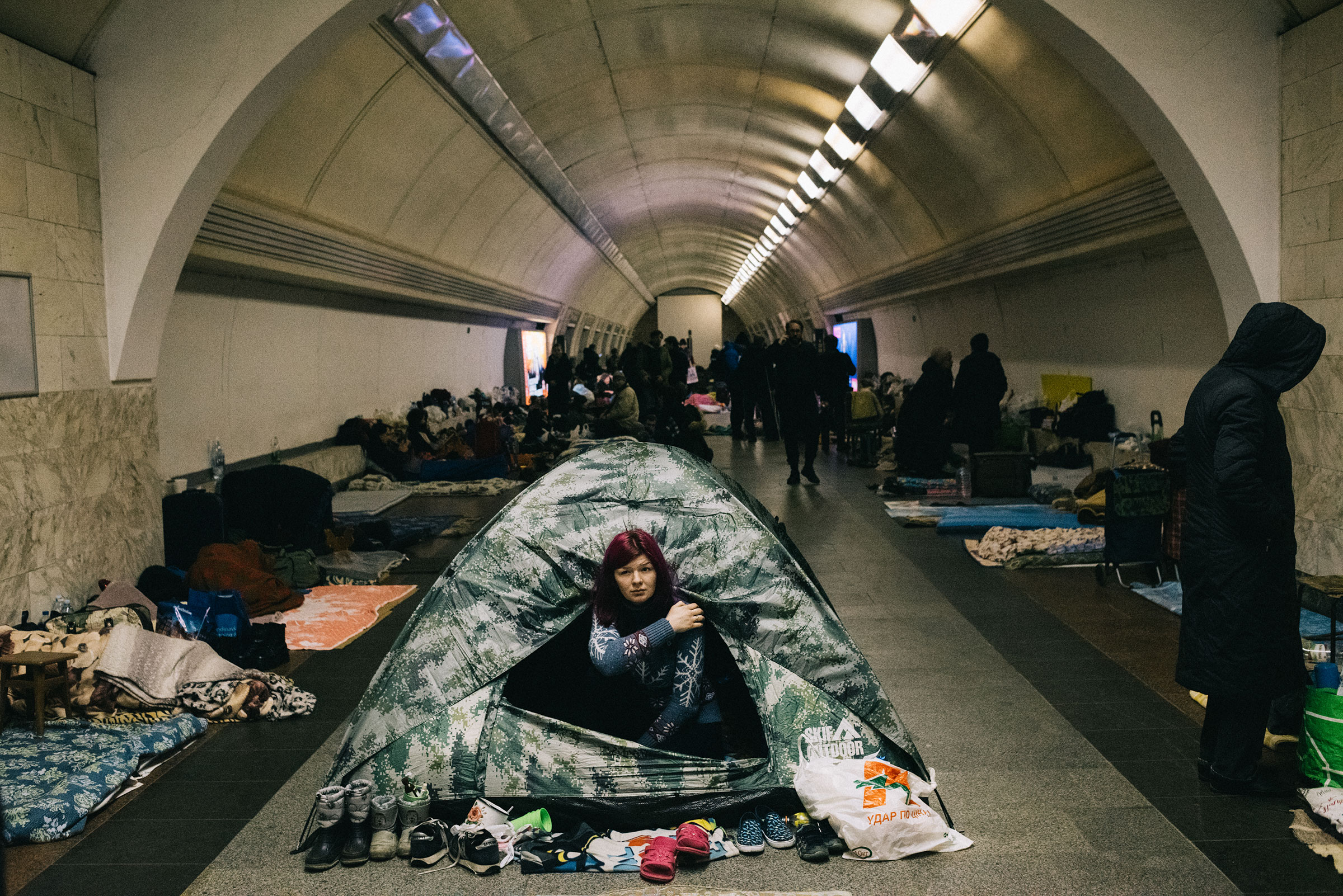 A woman seeks shelter from Russian artillery and aerial bombardment in Kyiv’s subway system on March 2. Thousands like her have retreated underground, and some have not left the tunnels since the fighting began (Maxim Dondyuk)