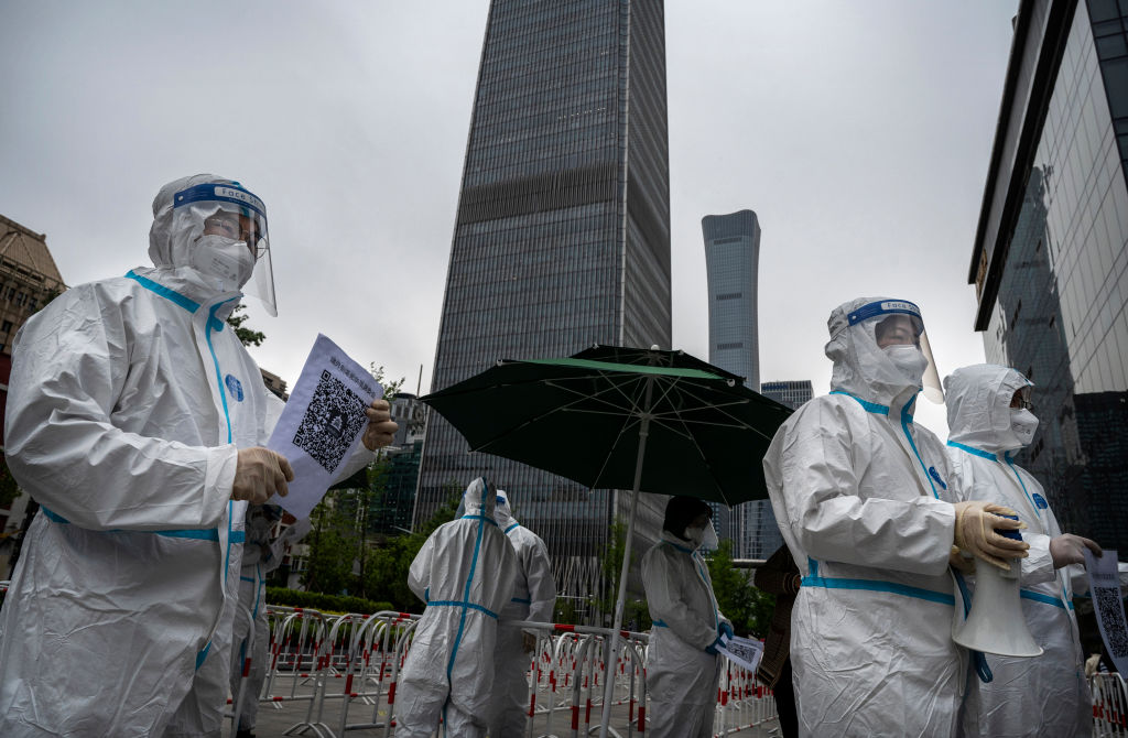 Health workers wear protective suits as they wait to register office workers for nucleic acid tests to detect COVID-19 at a makeshift testing site in the Central Business District in Chaoyang on April 27, 2022 in Beijing, China. (Kevin Frayer/Getty Images)