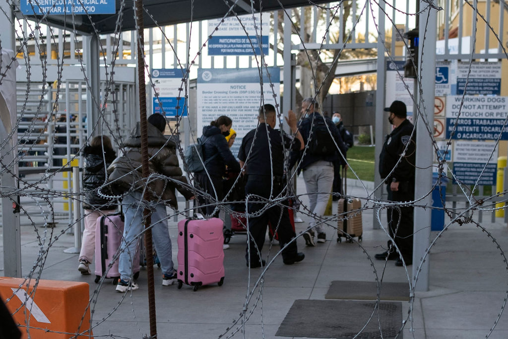 A group of people from Ukraine walk into the U.S. at the San Ysidro port of entry in Tijuana on March 12, 2022. (Guillermo Arias—AFP/Getty Images)
