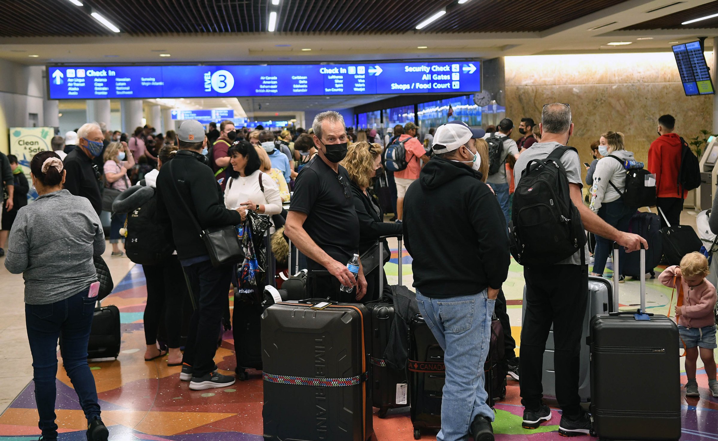 Spring break passengers wait in a TSA security line at