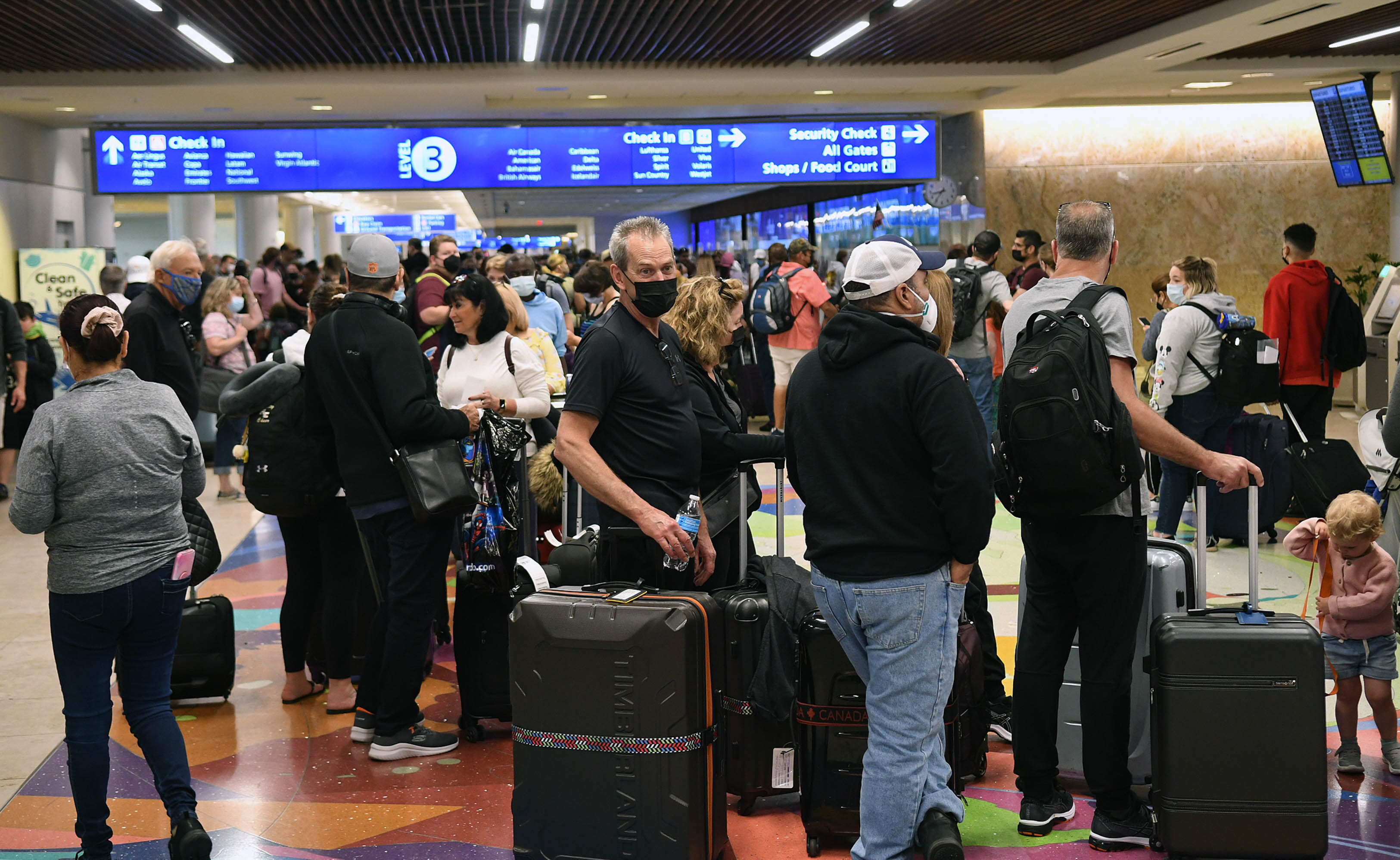 Spring break passengers wait in a TSA security line at