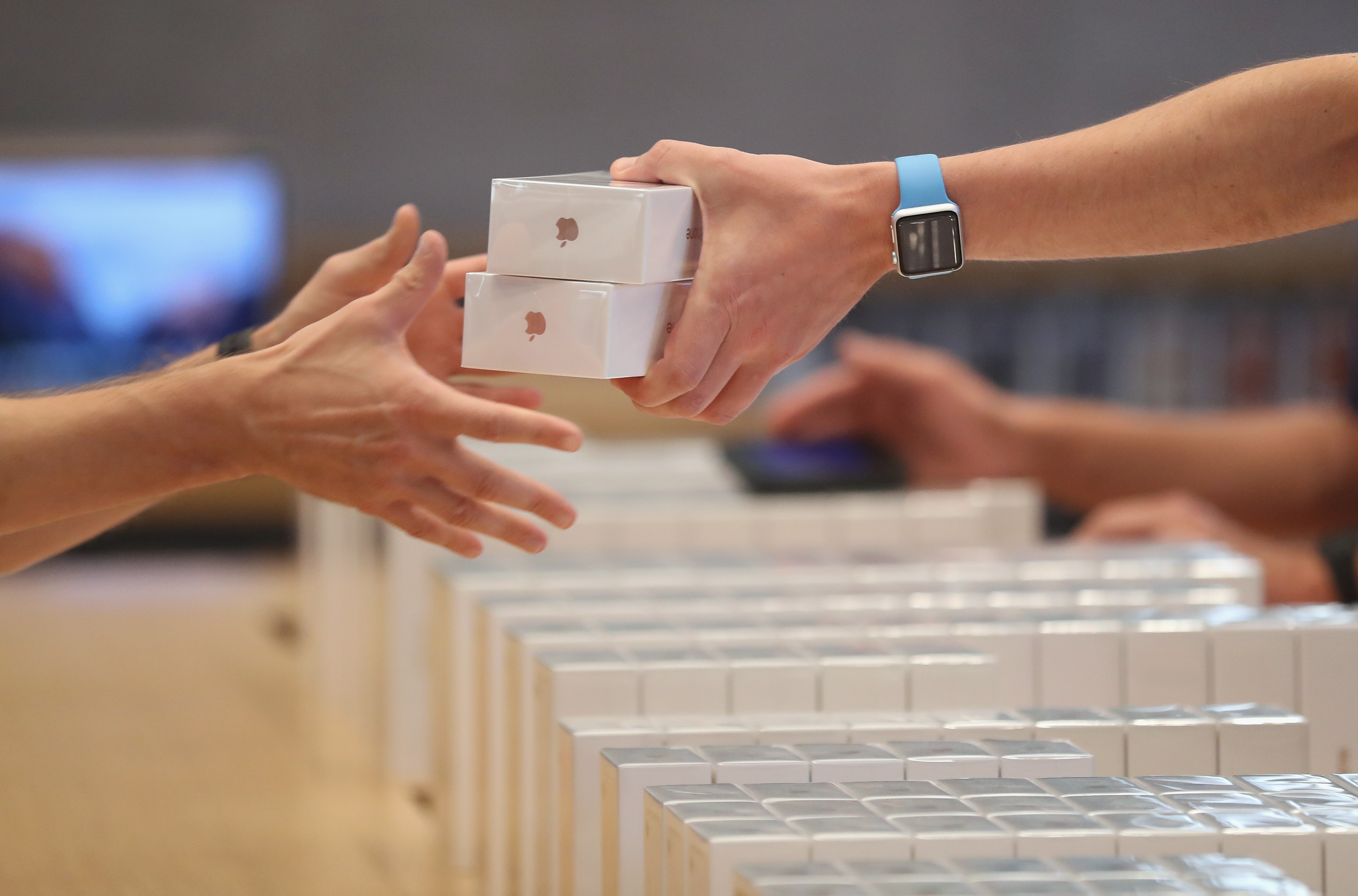 An Apple employee hands over Apple iPhone 7 phones on the first day of sales of the new phone at the Berlin Apple store on September 16, 2016 in Berlin, Germany. (Sean Gallup — Getty Images)