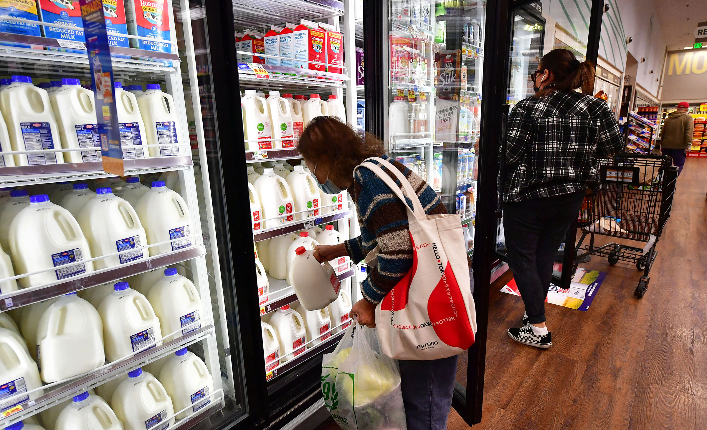 A person pulls out a gallon of milk as people shop at a grocery store in Monterey Park, Calif, on April 12, 2022. (Frederic J. Brown—AFP/Getty Images)