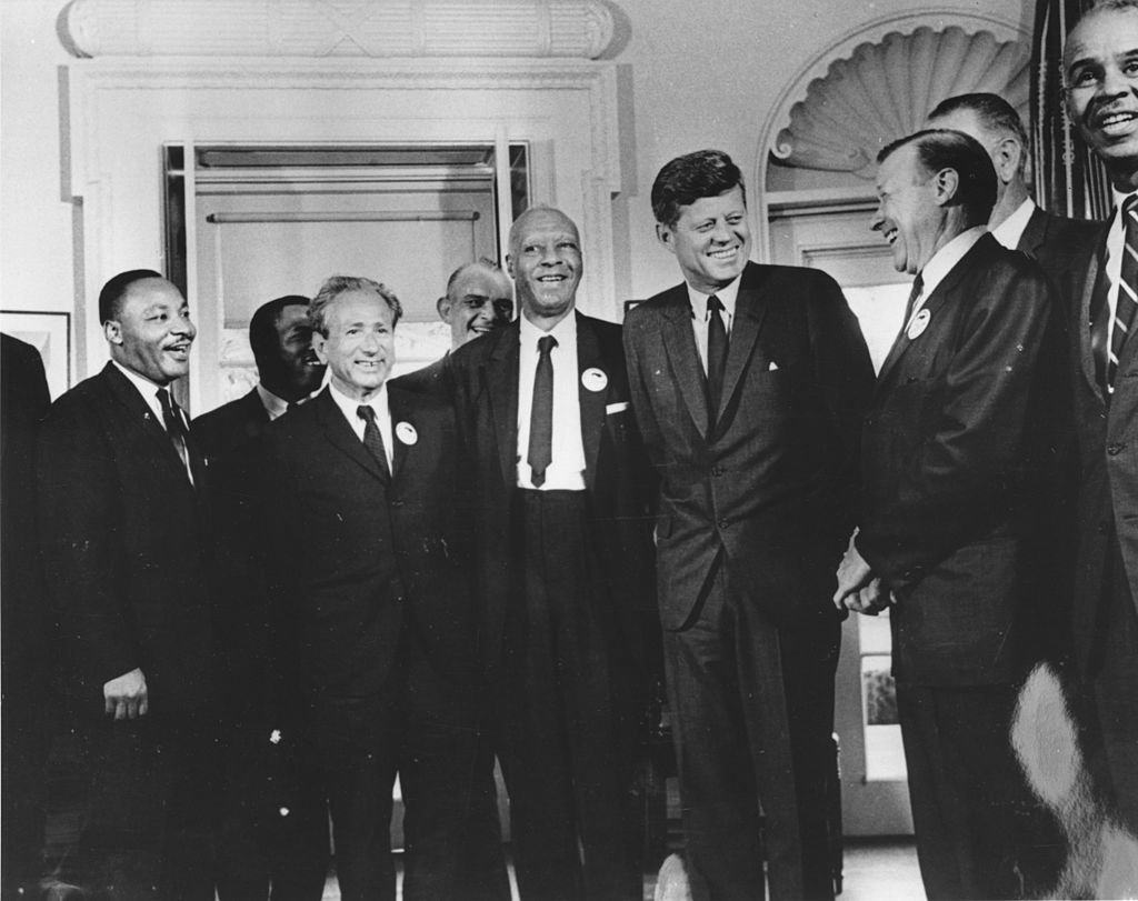 On Aug. 28, 1963, President John F. Kennedy poses in the White House with leaders of the March on Washington (left to right) Martin Luther King Jr., John Lewis, Rabbi Joachim Prinz, A. Philip Randolph, President Kennedy, Walter Reuther and Roy Wilkins. Behind Reuther is Vice-President Lyndon Johnson. (Three Lions/Hulton Archive—Getty Images)