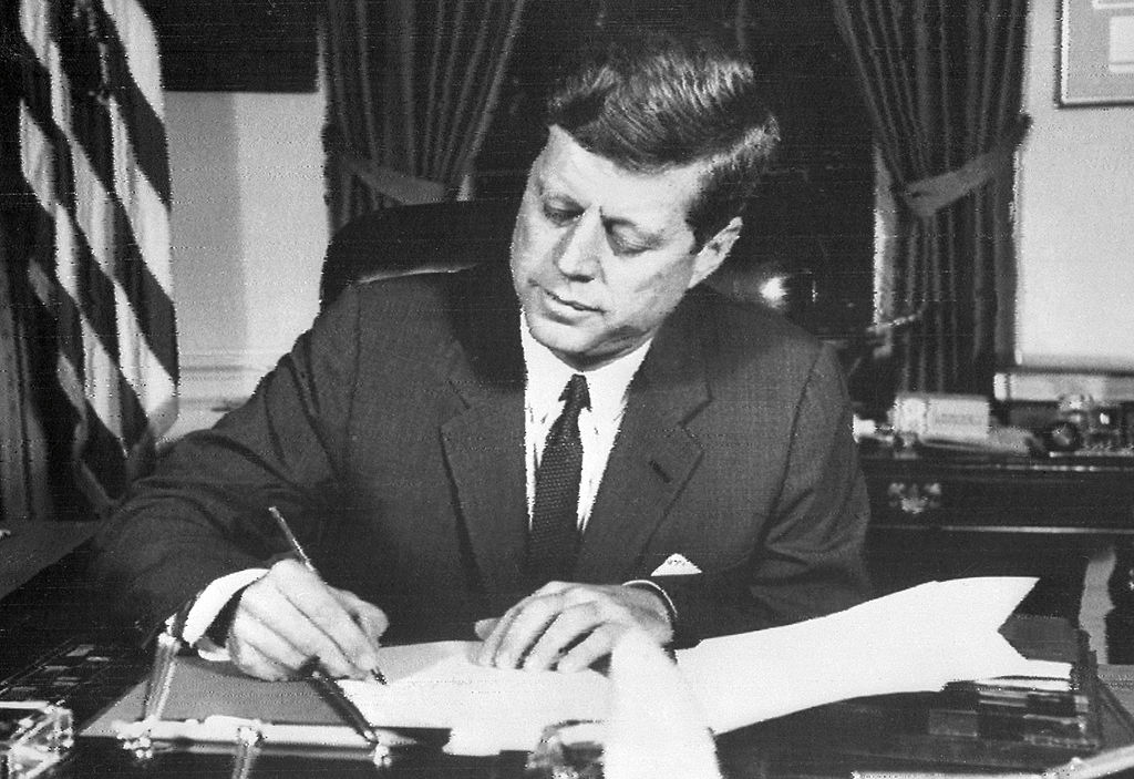 President John F. Kennedy signs the order of naval blockade of Cuba, on Oct. 24, 1962, at the White House, Washington, D.C., during the Cuban missile crisis. (AFP—Getty Images)