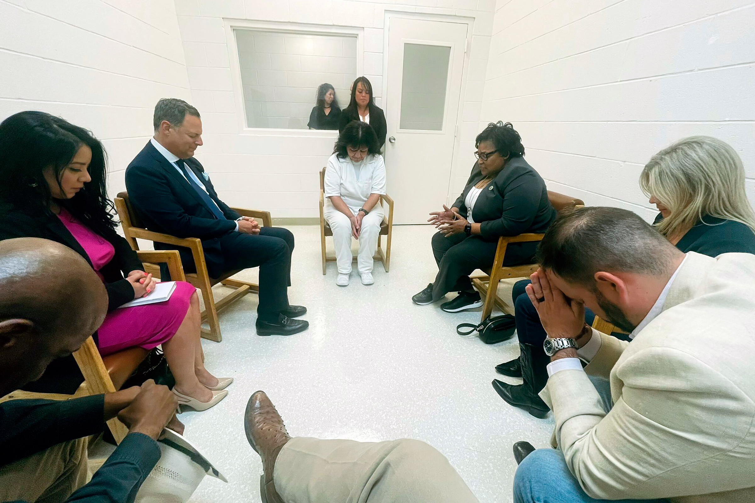 Melissa Lucio, center, leads a group of seven Texas lawmakers in prayer in a room at the Mountain View Unit in Gatesville, Texas, on April 6, 2022.