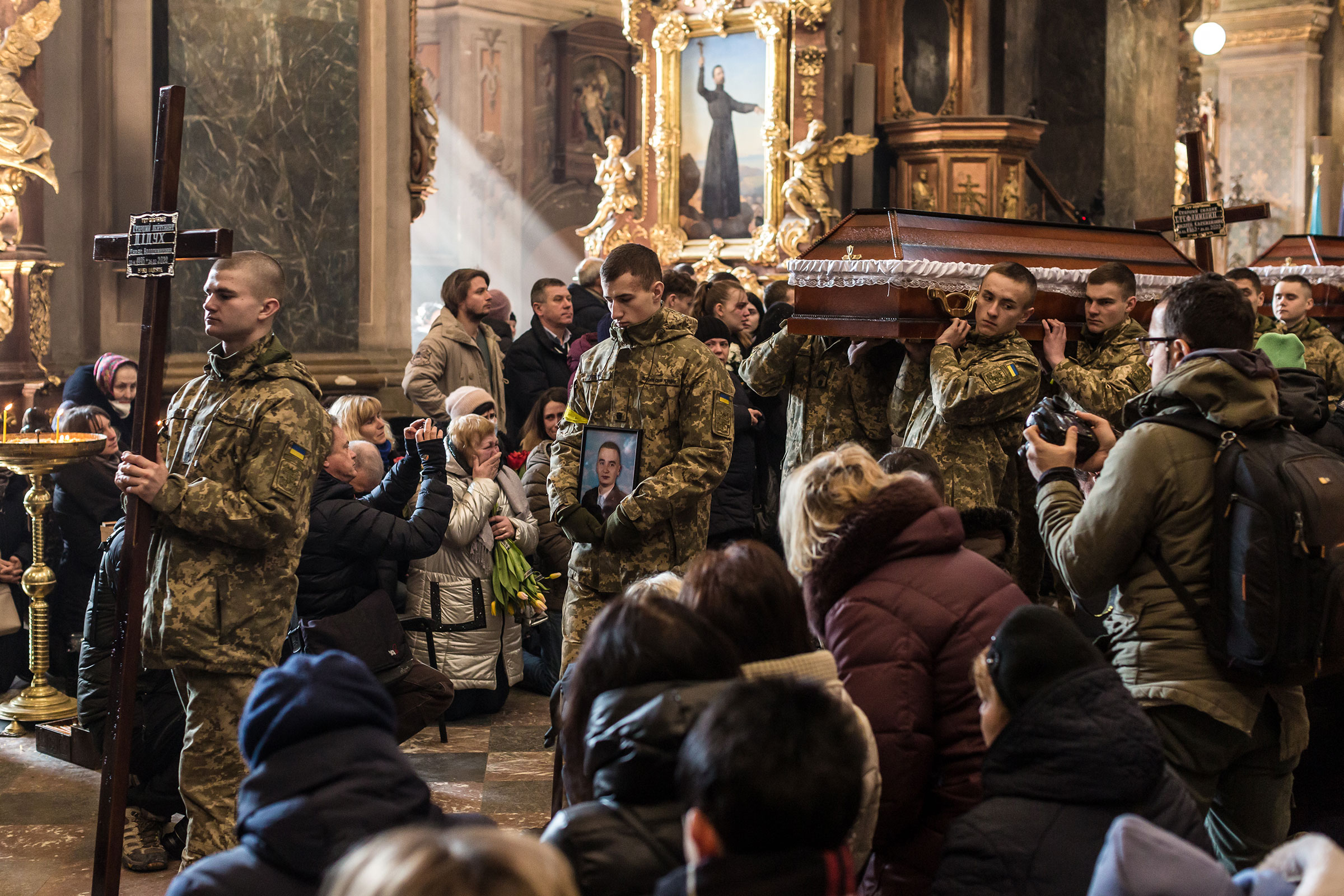 Fellow soldiers carry in the coffin of Taras Diduh, who was killed on Feb. 26 in the war, during a funeral ceremony held at the Church of the Most Holy Apostles Peter and Paul in Lviv on March 11, 2022. (Oksana Parafeniuk)