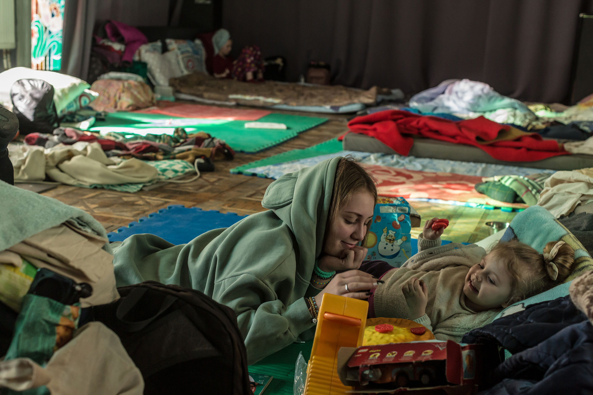 Kateryna, 16, plays with Dominika, 3, at a temporary shelter organized at the Lviv Regional Academic Puppet Theater in Lviv on March 11. (Oksana Parafeniuk)