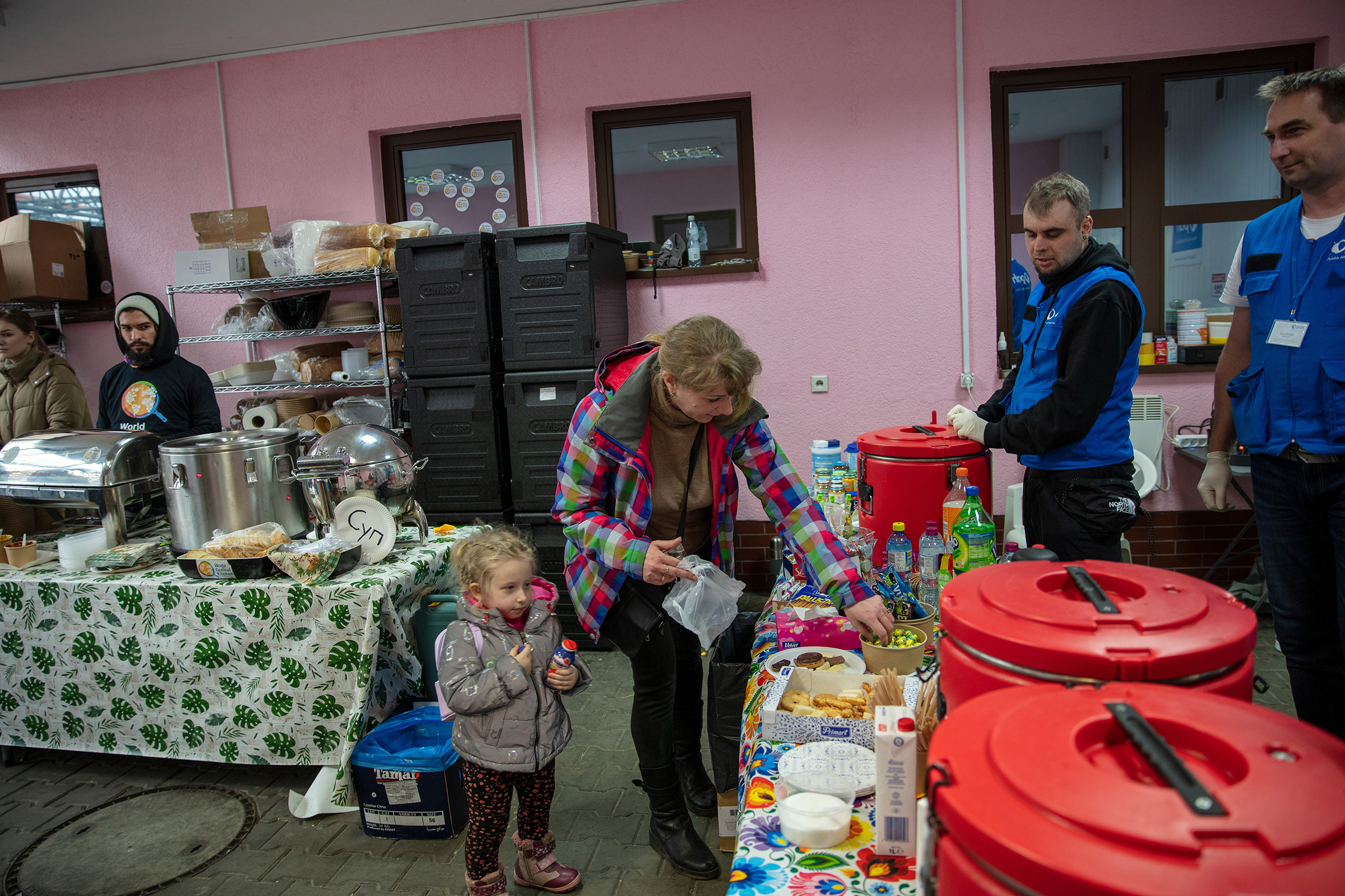 PAH volunteers assist Natalia Kzakova and her daughter, Sofia, who fled the fighting in their home of Mariupol, in Hrebrenne, Poland, on April 11, 2022. (Laura Noel—CARE)