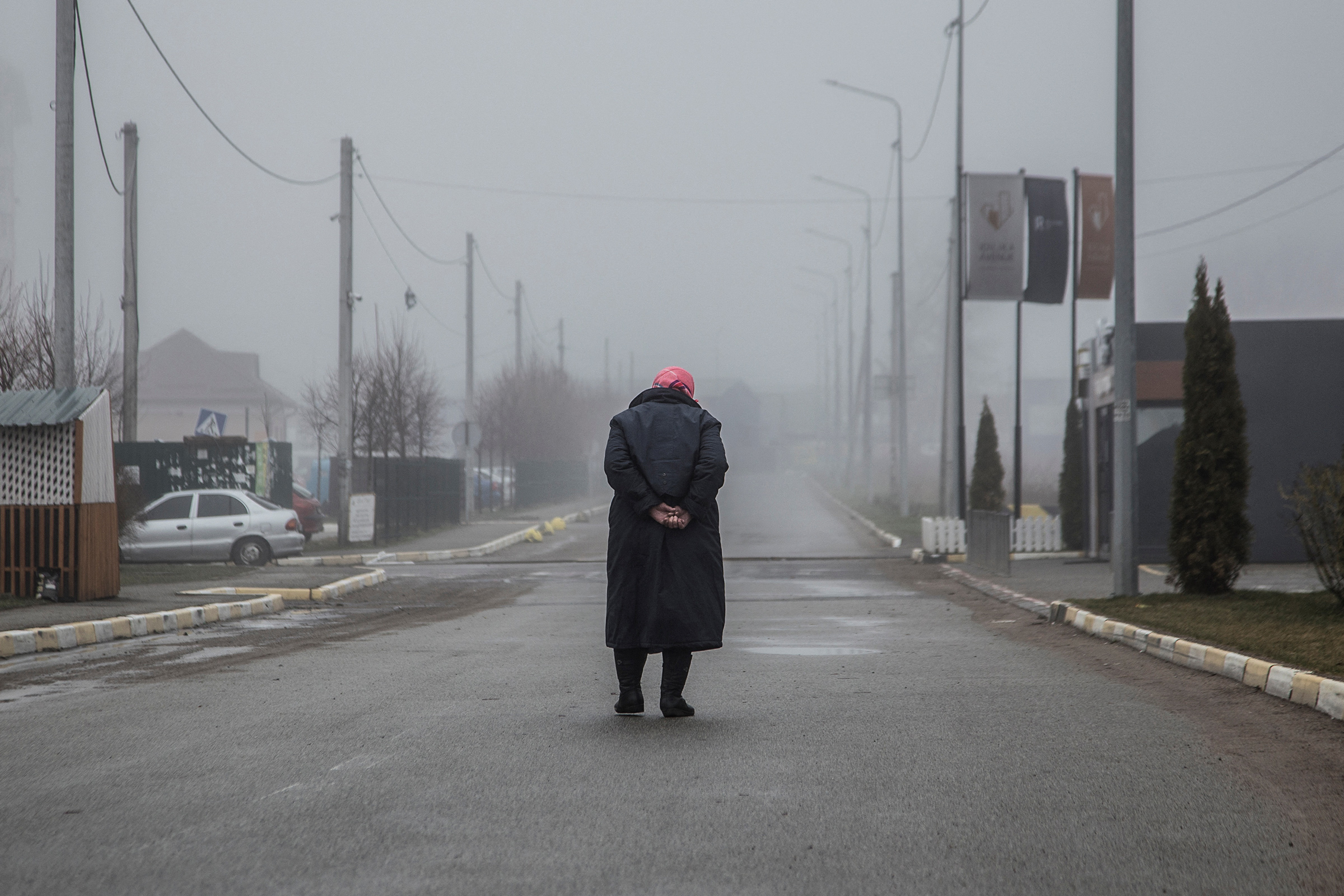 A woman walks along an empty street in Bucha, Ukraine, April 1, 2022.