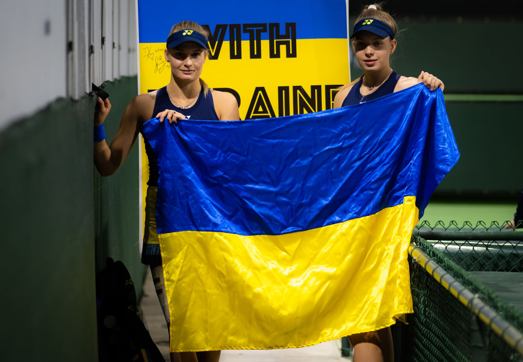 Dayana Yastremska of Ukraine and sister Ivanna Yastremska of Ukraine pose with a Ukrainian flag after their first round doubles match against Monica Niculescu of Romania and Irina-Camelia Begu of Romania at the 2022 BNP Paribas Open at the Indian Wells Tennis Garden on March 11, 2022 in Indian Wells, California. (Robert Prange—Getty Images)