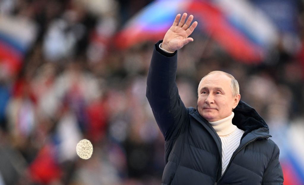 Russian President Vladimir Putin waves during a concert marking the eighth anniversary of Russia's annexation of Crimea at the Luzhniki stadium in Moscow on March 18, 2022. (Ramil Sitdikov/POOL/AFP—Getty Images))