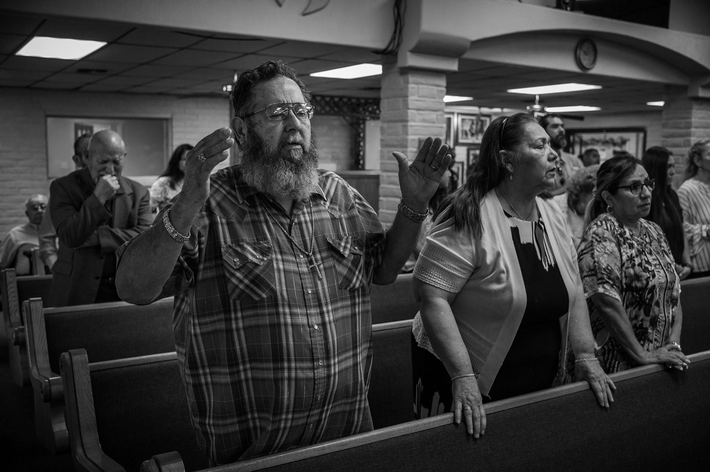 David Hernandez, left, prays with his wife Mary at the Templo Cristiano church on May 29, 2022. (David Butow for TIME)