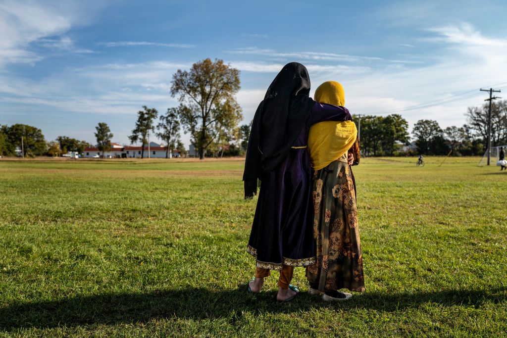 Afghan refugee girls watch a soccer match near where they are staying at the Ft. McCoy U.S. Army base in Ft. McCoy, Wis. on Sept. 30, 2021. (Barbara Davidson—POOL/AFP/Getty Images)