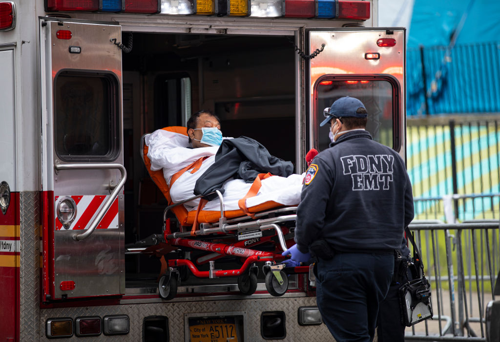 Members of the fire department of New York's emergency medical team wheel in a patient with coronavirus to a hospital on March 30, 2020. (Robert Nickelsberg—Getty Images)